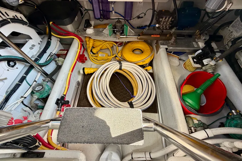 Slide: The Image of Engine room of a 2016 Nordic Tug 44 with hoses, cables, and equipment. - 104