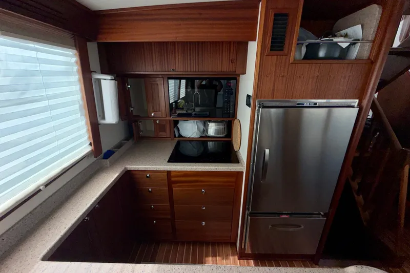 Slide: The Image of Compact kitchen in a 2016 Nordic Tug 44, featuring wood cabinetry and stainless steel appliances. - 37