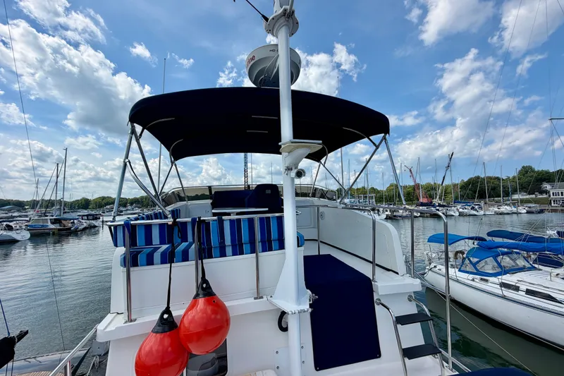 Slide: The Image of Nordic Tug 44 (2016) docked at marina, featuring blue-striped seating and clear skies. - 19