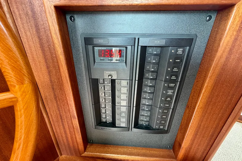 Slide: The Image of Electrical panel of a 2016 Nordic Tug 44 boat, featuring switches and a digital display. - 64