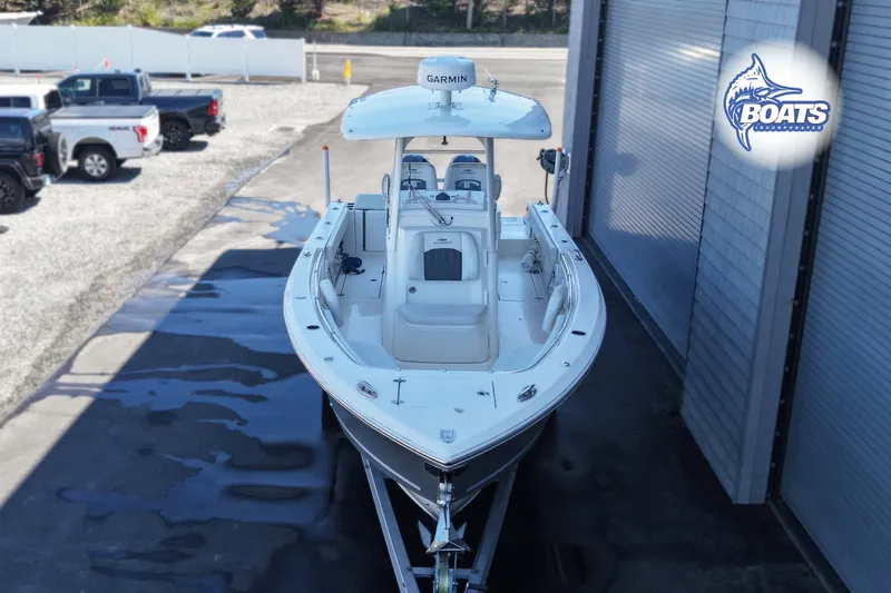 Slide: The Image of 2023 Cobia 262 Center Console boat on trailer, parked near trucks. - 2