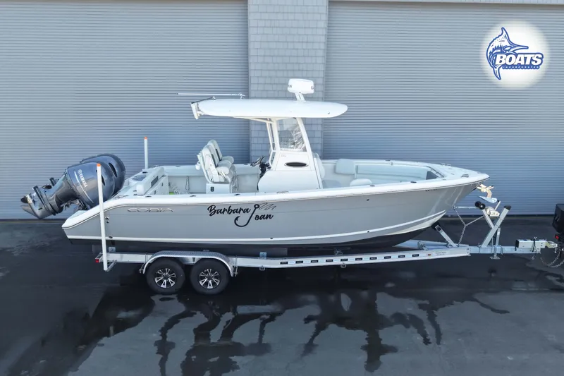 The Image of 2023 Cobia 262 Center Console boat on trailer, side view, with twin engines. - 0