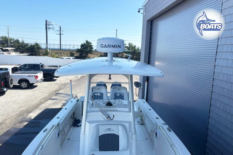 Slide: The Image of 2023 Cobia 262 Center Console boat with Garmin equipment, parked near a building. - 8