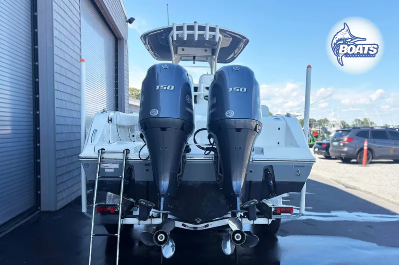 Slide: The Image of 2023 Cobia 262 Center Console boat with dual Yamaha 150 engines, parked outdoors. - 15