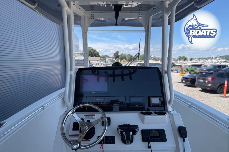 Slide: The Image of 2023 Cobia 262 Center Console boat dashboard with steering wheel and navigation equipment. - 9