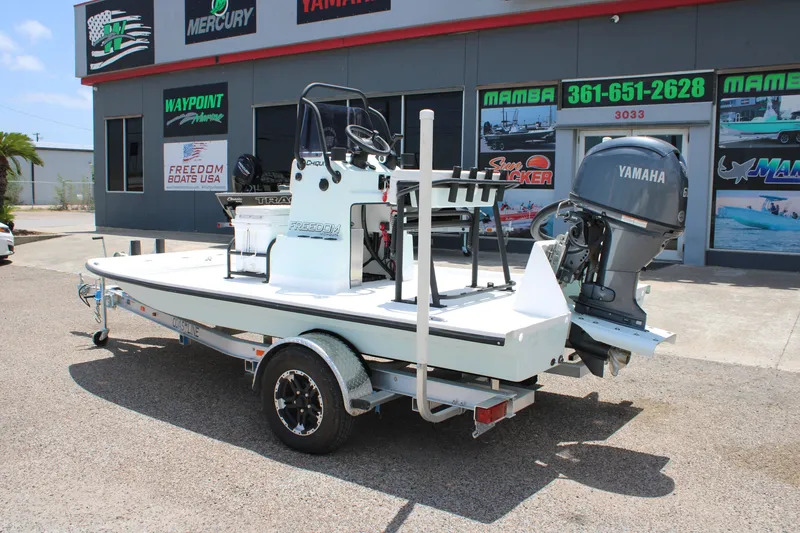 Slide: The Image of 2027 Freedom Boats Chiquita with Yamaha engine on trailer outside dealership. - 2
