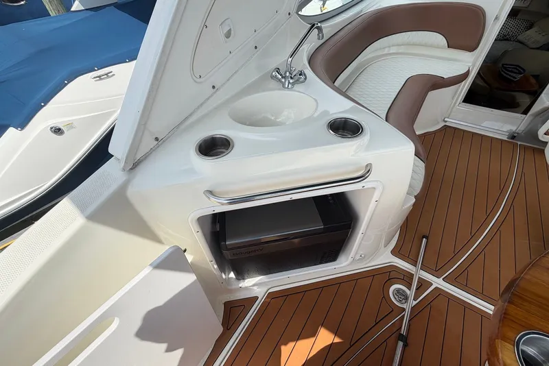 Slide: The Image of 2008 Bayliner 300 boat interior with sink, seating, and wood-patterned flooring. - 8