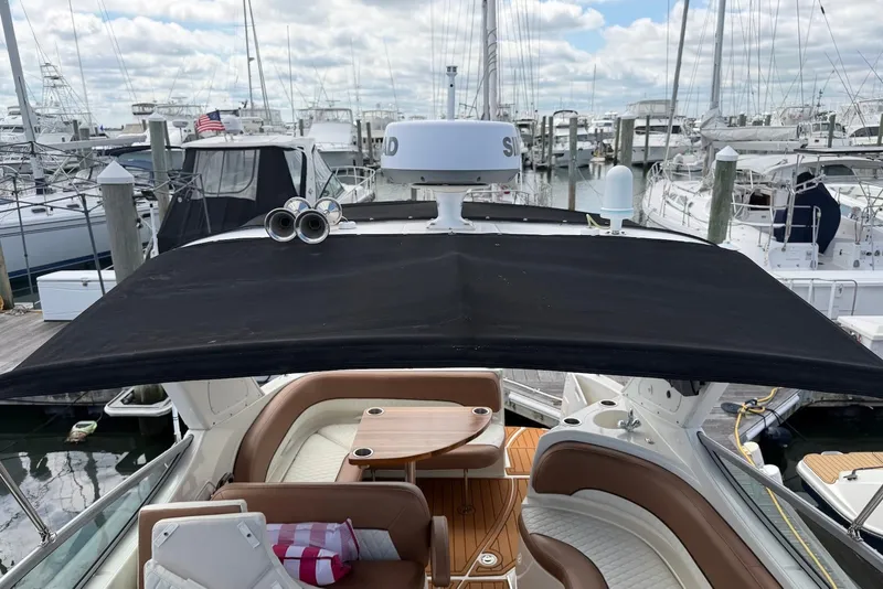 Slide: The Image of 2008 Bayliner 300 boat with canopy, docked at marina, surrounded by other vessels. - 4