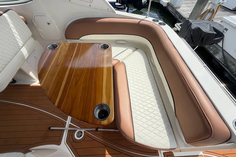 Slide: The Image of Luxurious seating area on a 2008 Bayliner 300 boat with wooden table and cup holders. - 7