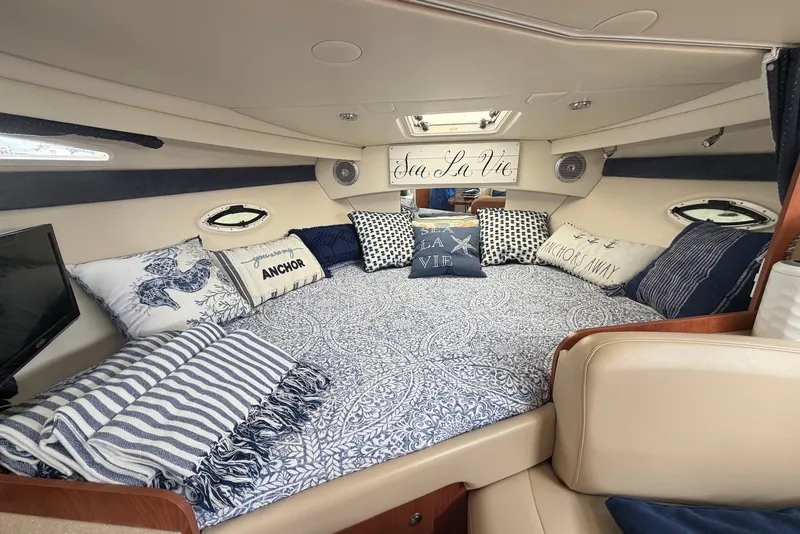 Slide: The Image of Luxurious interior of a 2008 Bayliner 300 boat with nautical-themed bedding. - 15