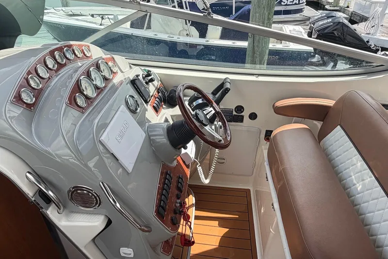 Slide: The Image of 2008 Bayliner 300 boat cockpit with steering wheel, gauges, and brown seating. - 9