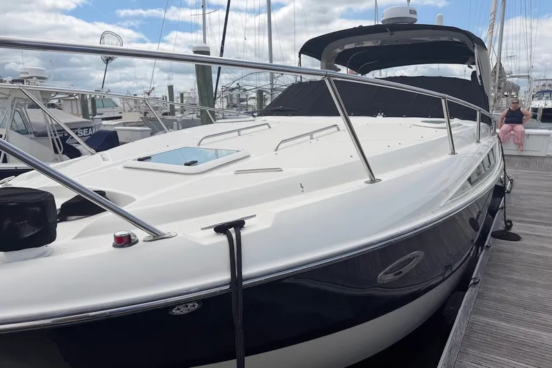 Slide: The Image of 2008 Bayliner 300 boat docked at marina under cloudy sky. - 2