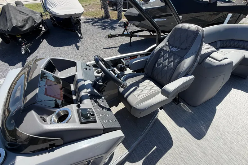 Slide: The Image of 2022 Bennington 25 QX boat interior with luxurious captain's chair and modern dashboard. - 19