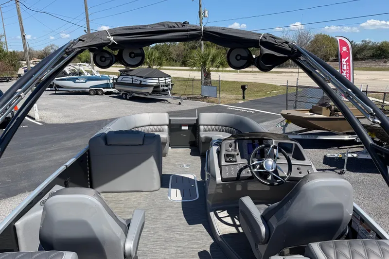 Slide: The Image of 2022 Bennington 25 QX pontoon boat interior with helm, seating, and canopy. - 28