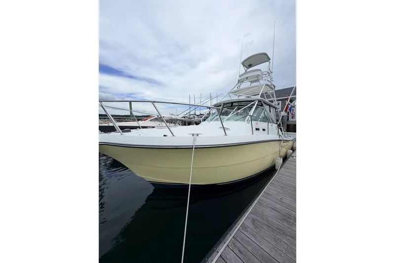 The Image of 2003 Rampage 38 Express boat docked at marina under cloudy sky. - 0