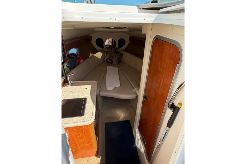 Slide: The Image of 2009 Rinker 260 Express Cruiser cabin interior with seating and kitchenette. - 18