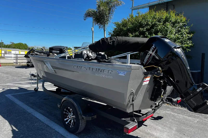 Slide: The Image of 2023 Crestliner 1600 Vision boat on trailer, parked outdoors under clear sky. - 4