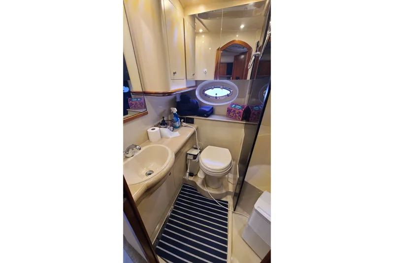 Slide: The Image of Bathroom interior of 2006 Cruisers Yachts 370 Express with sink, toilet, and striped rug. - 29