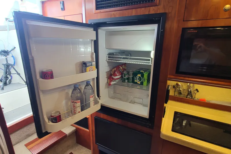 Slide: The Image of Open fridge in 2006 Cruisers Yachts 370 Express galley, stocked with drinks and snacks. - 25