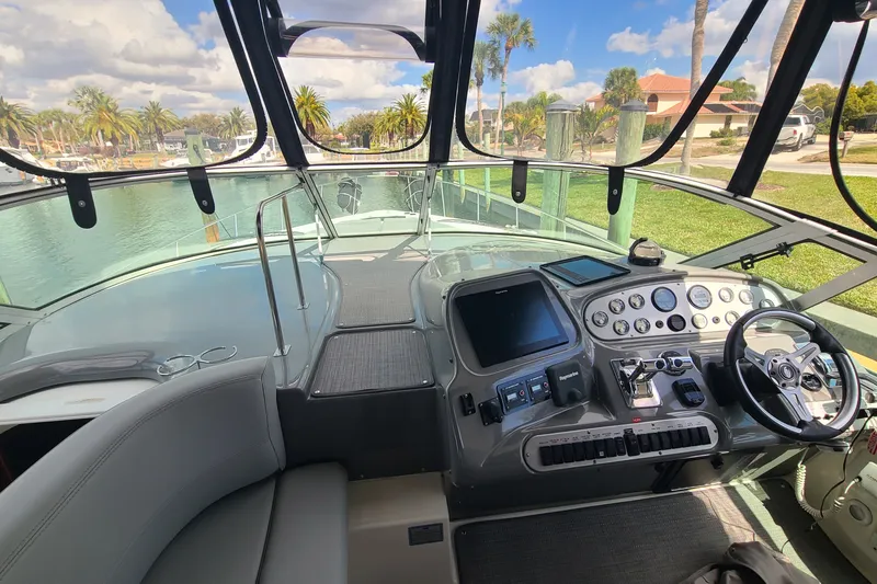 Slide: The Image of Cockpit view of 2006 Cruisers Yachts 370 Express with modern controls and scenic marina backdrop. - 16