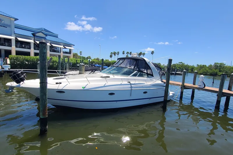 The Image of 2006 Cruisers Yachts 370 Express docked at marina under clear blue sky. - 0