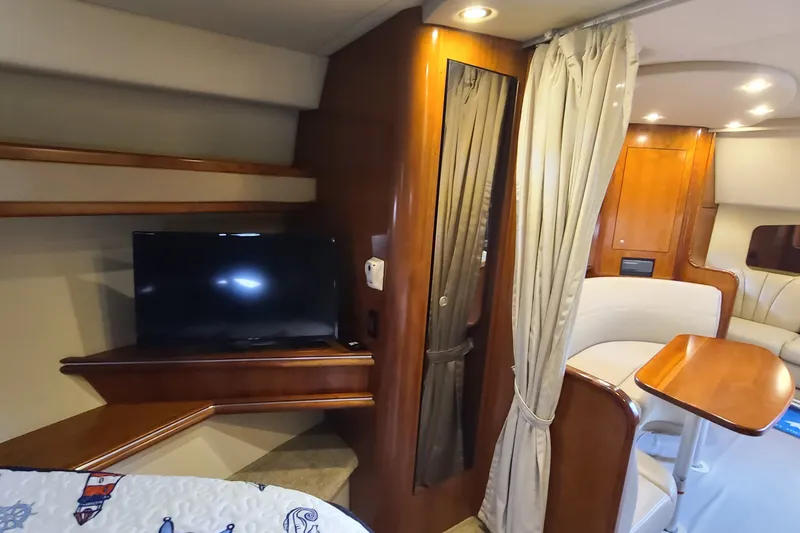 Slide: The Image of 2006 Cruisers Yachts 370 Express interior with TV, wood finishes, and cozy seating area. - 23