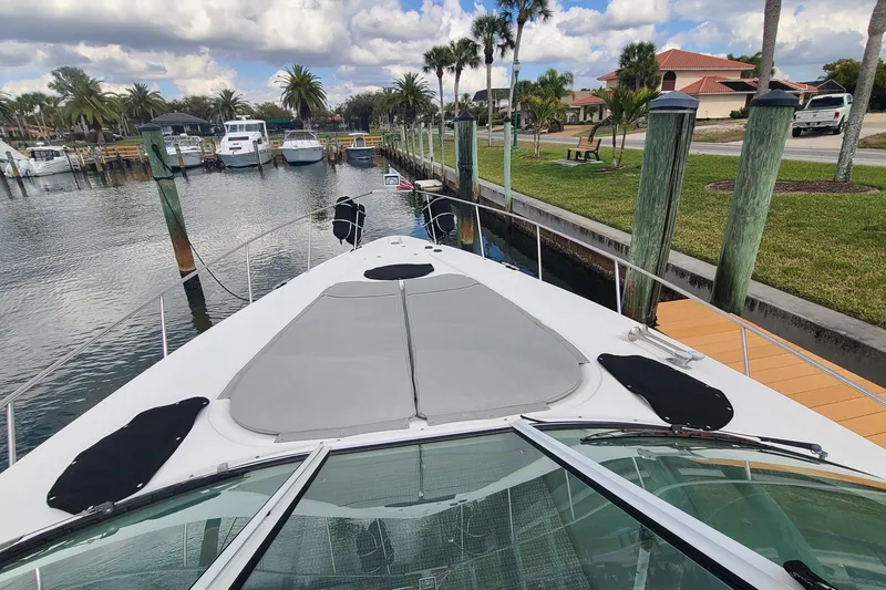 Slide: The Image of 2006 Cruisers Yachts 370 Express docked at a marina with palm trees and boats. - 17