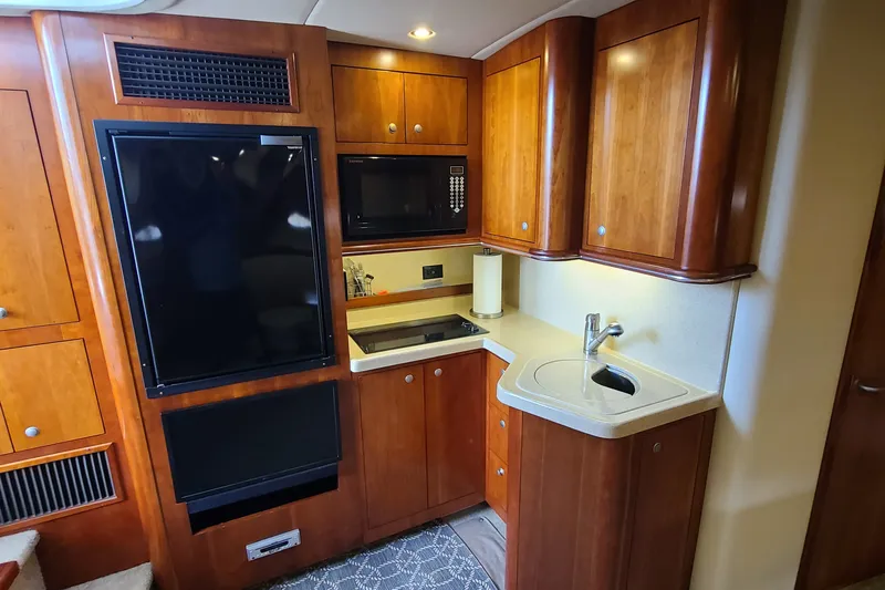 Slide: The Image of 2006 Cruisers Yachts 370 Express interior kitchen with wood cabinets and modern appliances. - 21