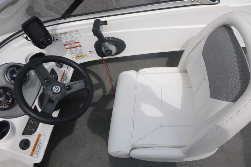 Slide: The Image of 2016 Bayliner 175 Bowrider cockpit with steering wheel, controls, and white captain's chair. - 8
