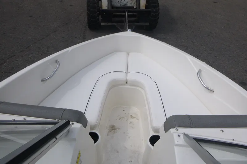 Slide: The Image of 2016 Bayliner 175 Bowrider boat interior with white seating and metal handles. - 7