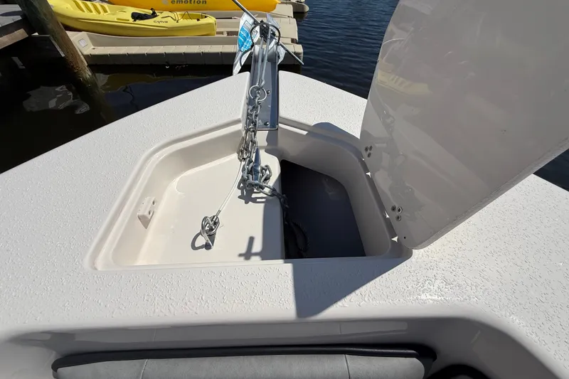 Slide: The Image of Open anchor compartment on 2025 Sea Chaser 22 HFC boat, docked near kayaks. - 16