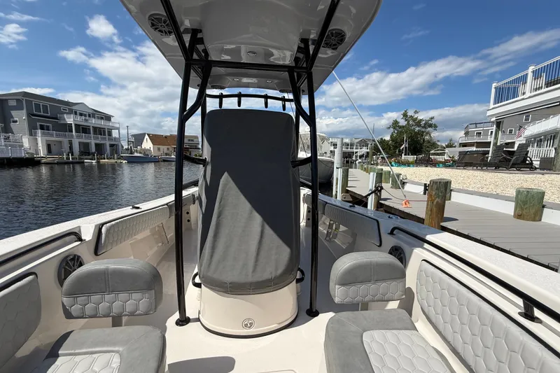 Slide: The Image of 2025 Sea Chaser 22 HFC boat interior with seating, docked by waterfront homes. - 15