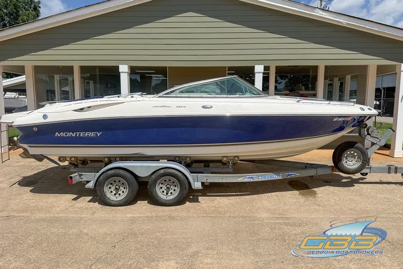 Slide: The Image of 2005 Monterey 228SI Montura Bowrider on trailer, parked outside a building. - 9