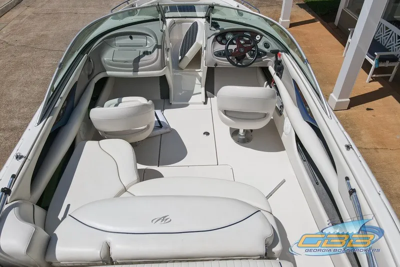Slide: The Image of 2005 Monterey 228SI Montura Bowrider interior with white seating and dashboard view. - 4