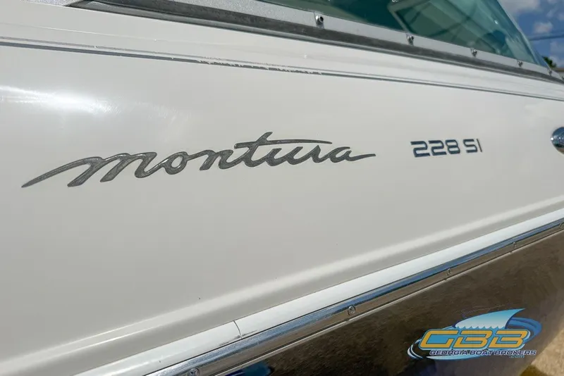Slide: The Image of 2005 Monterey 228SI Montura Bowrider boat side view with logo and branding. - 7