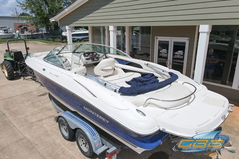 Slide: The Image of 2005 Monterey 228SI Montura Bowrider on trailer, parked outside a building. - 2