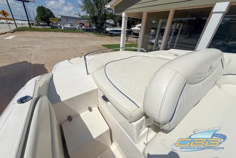 Slide: The Image of 2005 Monterey 228SI Montura Bowrider with white seating, displayed outdoors at a dealership. - 18