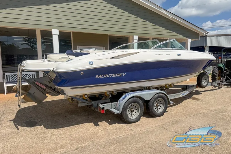 Slide: The Image of 2005 Monterey 228SI Montura Bowrider on trailer, parked outside a building. - 8
