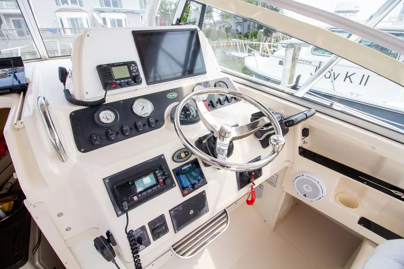 Slide: The Image of The cockpit of the 2004 Grady-White Marlin 300 features a modern helm with multiple instruments. - 43