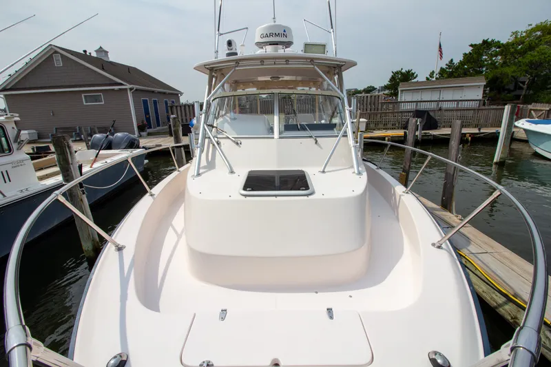 Slide: The Image of The 2004 Grady-White Marlin 300 is docked, featuring a spacious foredeck. - 14
