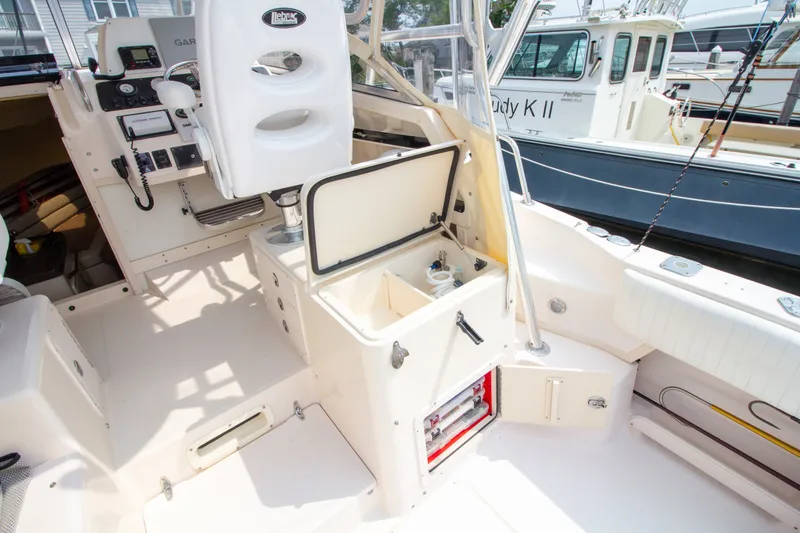 Slide: The Image of The cockpit of a 2004 Grady-White Marlin 300 with helm station and storage compartments. - 32