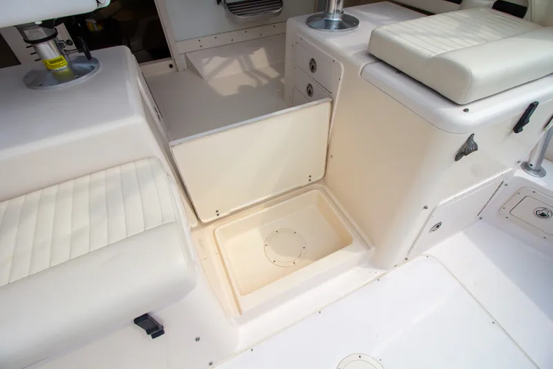 Slide: The Image of The image shows the interior of a 2004 Grady-White Marlin 300 boat with white cushioned seating and storage. - 39