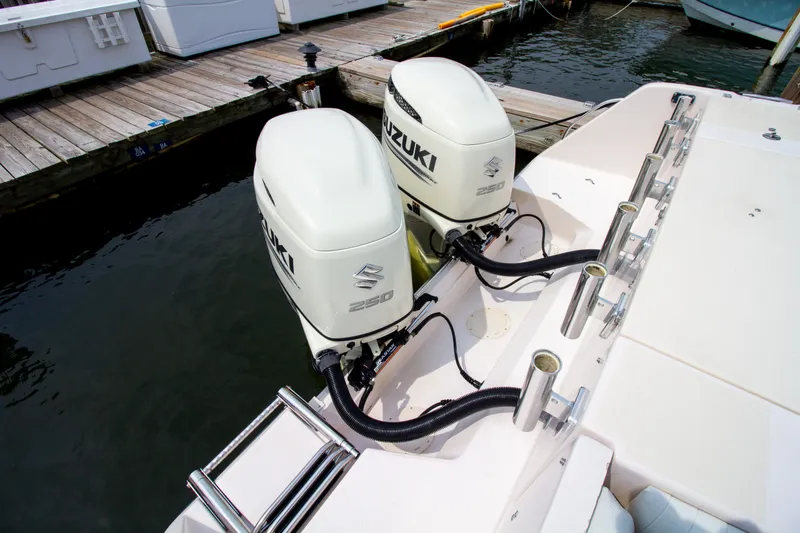 Slide: The Image of Two Suzuki outboard engines on a Grady-White Marlin 300 boat, docked at a wooden pier. - 9
