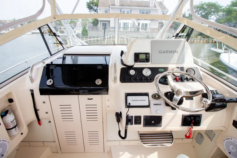 Slide: The Image of The cockpit of a 2004 Grady-White Marlin 300 features a modern helm with Garmin navigation. - 50