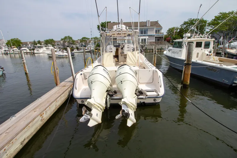 Slide: The Image of A 2004 Grady-White Marlin 300 is docked in the water. Two outboard engines are visible. - 4