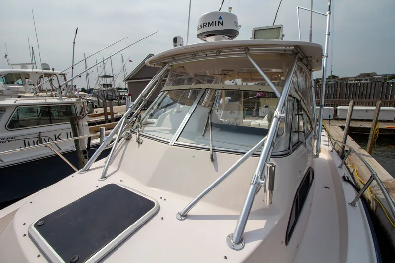 Slide: The Image of 2004 Grady-White Marlin 300 docked, featuring radar antennas and fishing rod holders. - 17