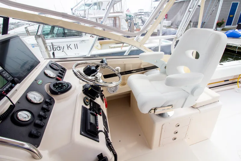 Slide: The Image of The cockpit of a 2004 Grady-White Marlin 300 with a white captain's chair and instrument panel. - 48