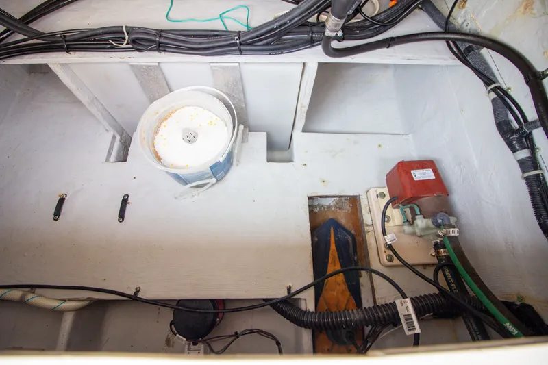 Slide: The Image of A view inside the engine compartment of a 2004 Grady-White Marlin 300 boat with cables and equipment. - 27
