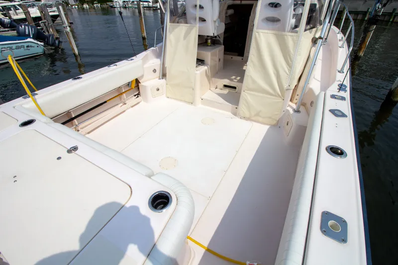 Slide: The Image of The image shows the spacious cockpit of a 2004 Grady-White Marlin 300, docked at a marina. - 20