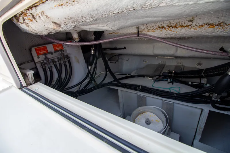 Slide: The Image of A view inside the engine compartment of a 2004 Grady-White Marlin 300, showing cables and hoses. - 25